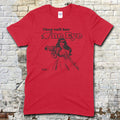 Red t-shirt featuring a black graphic of a woman pointing a gun with They call her One Eye text on front