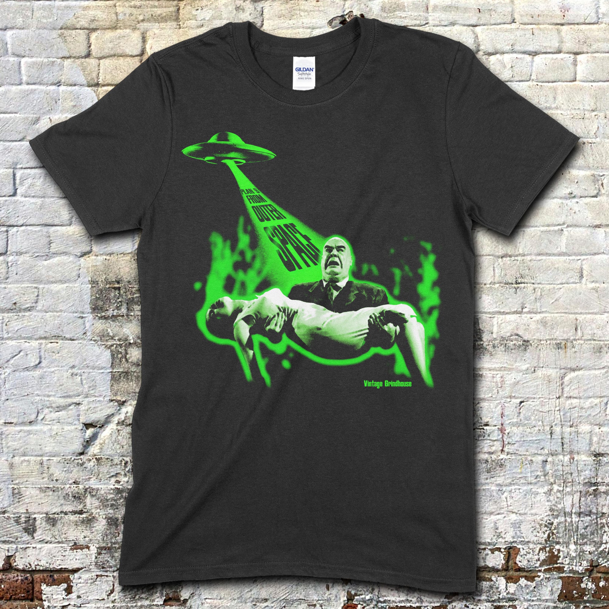 Black t-shirt featuring vintage green alien spaceship beam abducting a man holding a woman with Plan 9 from Outer Space text on front