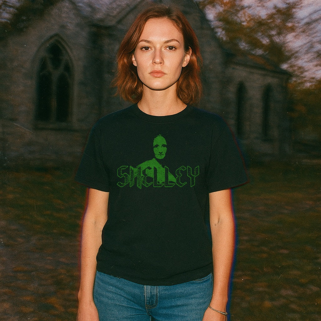 Mary Shelley t-shirt in black with a green gothic font and a stylized portrait on front worn outdoors near stone building