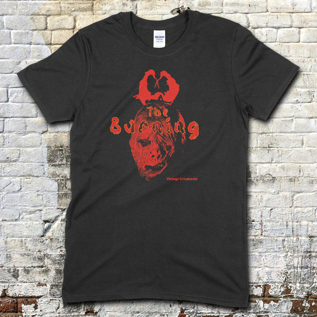 Black t-shirt featuring a red graphic of a masked face and The Burning text in a vintage style on front