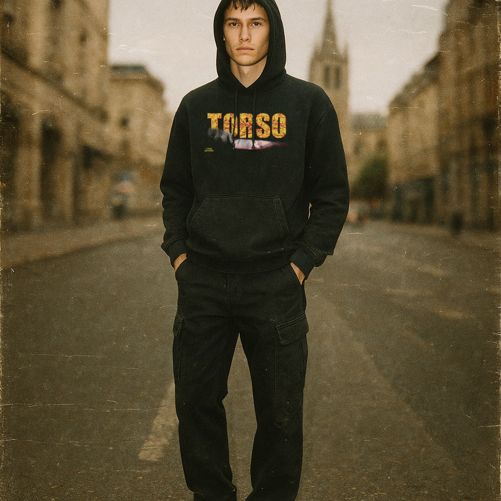 Person wearing a black hoodie with 'TORSO' printed on it in an urban setting