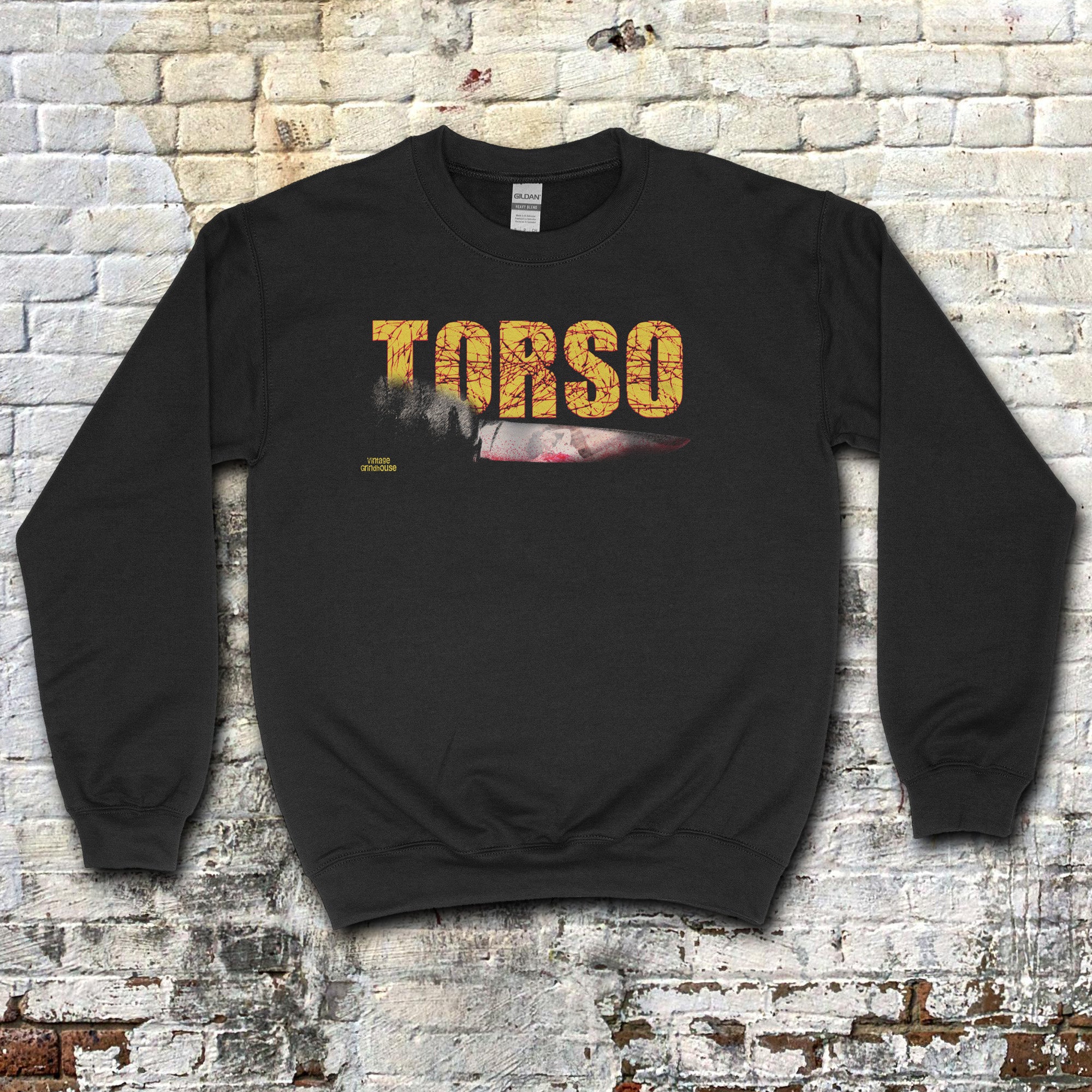 Torso sweatshirt with distressed yellow text and graphic of a bloody knife on black fabric against brick wall background