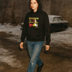 Person wearing a black hoodie with a graphic design, standing in a snowy landscape.