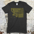 Dark gray t-shirt with vintage-style yellow block print featuring a seated figure and The Yellow Wallpaper text