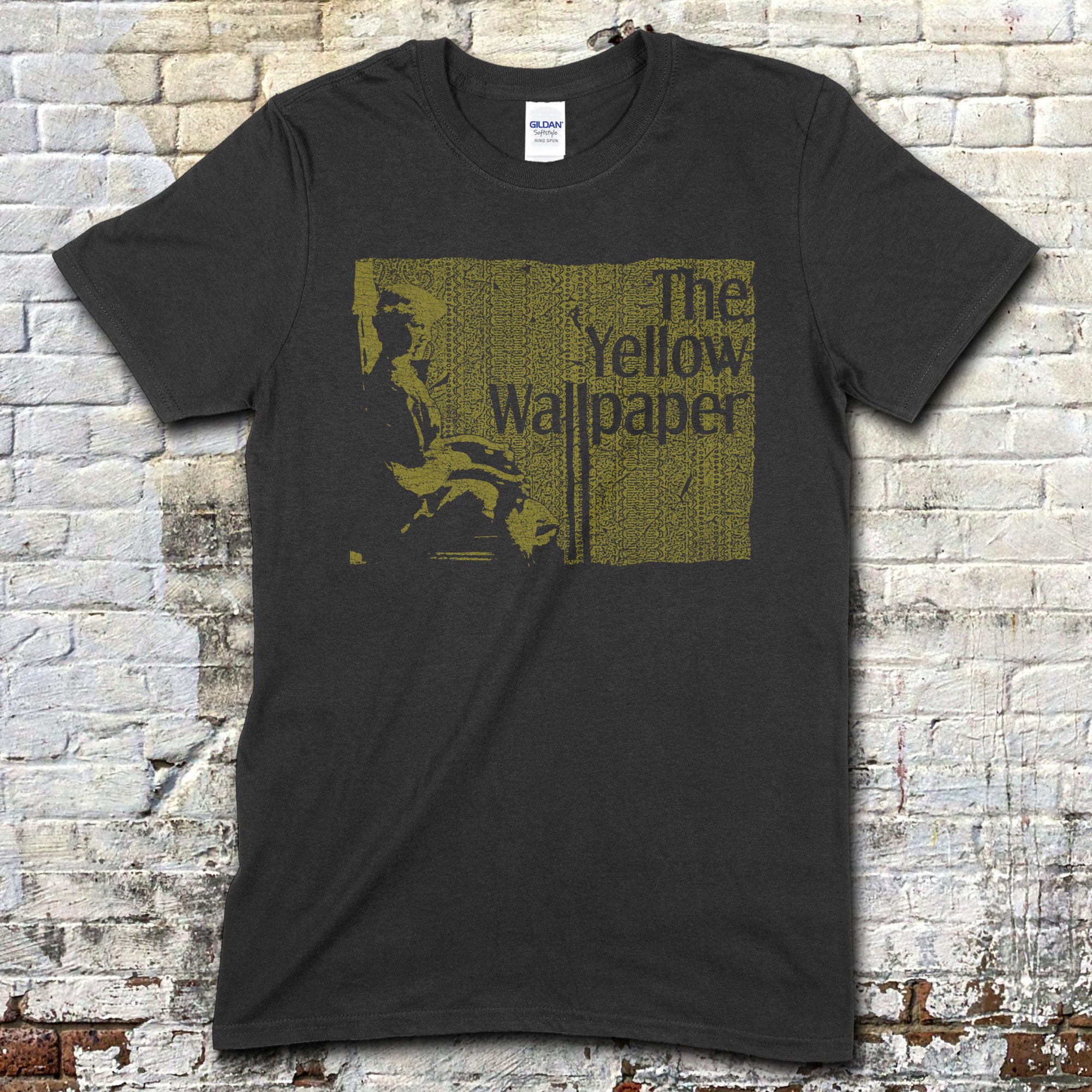 Dark gray t-shirt with vintage-style yellow block print featuring a seated figure and The Yellow Wallpaper text