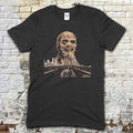 Black t-shirt featuring a large zombie face graphic above a cityscape and bridge with vintage horror text on front